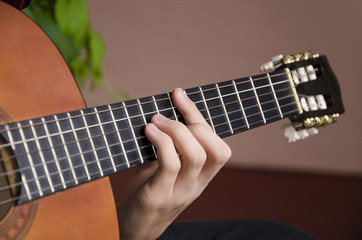 Obraz premium Closeup of chord on classic guitar. Selective focus on main finger
