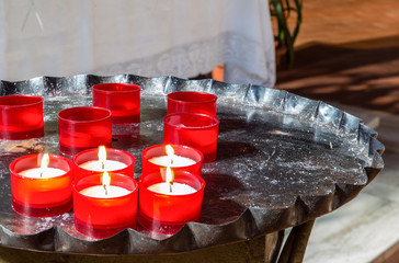 red votive candles on iron candlestick