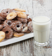 Seet fresh cookies with a cup of milk over wooden vintage background