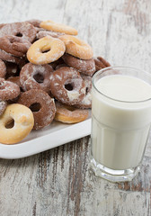 Seet fresh cookies with a cup of milk over wooden vintage background