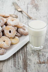 Seet fresh cookies with a cup of milk over wooden vintage background