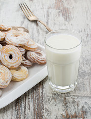 Seet fresh cookies with a cup of milk over wooden vintage background