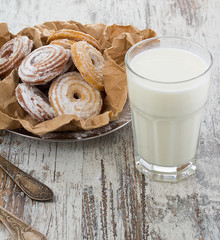 Seet fresh cookies with a cup of milk over wooden vintage background