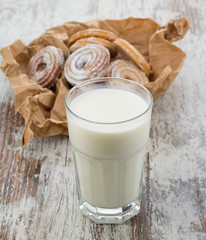 Seet fresh cookies with a cup of milk over wooden vintage background