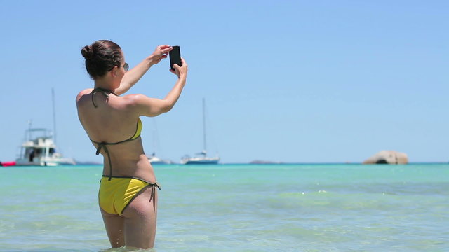 
Happy girl on vacations taking self photo on sea background at the beach