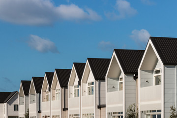 row of white houses against blue sky © Patrik Stedrak