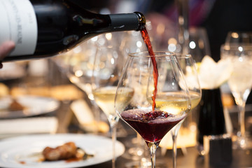 Kellnerin gießt Rotwein in das Glas auf dem Tisch im Restaurant?