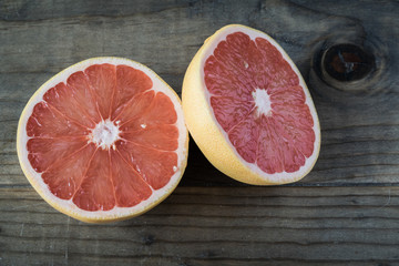 Fototapeta na wymiar Sliced Grapefruit Cut in Half on Wooden Table