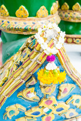 Close up at small jasmine garland at foot of thai giant sculptur