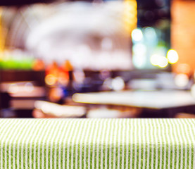 Table with green pattern tablecloth with blur restaurant backgro