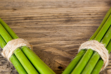 Green garlic sticks on rustic wooden table with copy space
