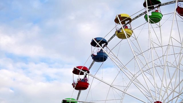 Ferris Wheel with colorful cabins in amusement park 