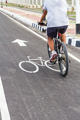 Fototapeta na wymiar A man have an exercise by riding bicycle on a bike lane