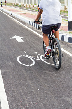 A man have an exercise by  riding bicycle on a bike lane
