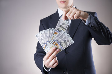 Businessman with money in studio on a gray background