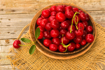 Cherries on wooden table with water drops macro background
