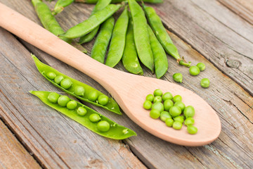 Freshly picked green peas on a wooden table.