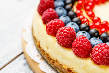 Raspberry and blueberry cheesecake on wooden table