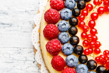 Raspberry and blueberry cheesecake on wooden table