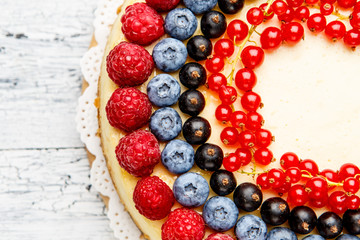 Raspberry and blueberry cheesecake on wooden table