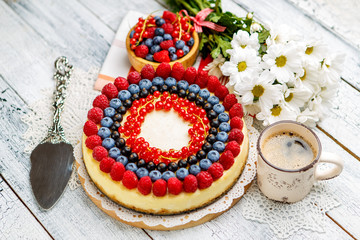 Raspberry and blueberry cheesecake on wooden table