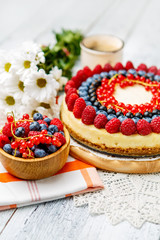 Raspberry and blueberry cheesecake on wooden table