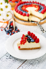 Raspberry and blueberry cheesecake on wooden table