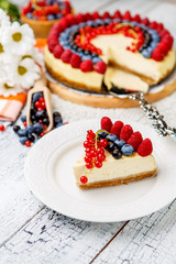 Raspberry and blueberry cheesecake on wooden table