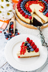 Raspberry and blueberry cheesecake on wooden table