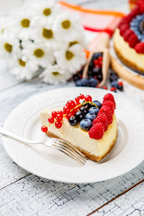 Raspberry and blueberry cheesecake on wooden table