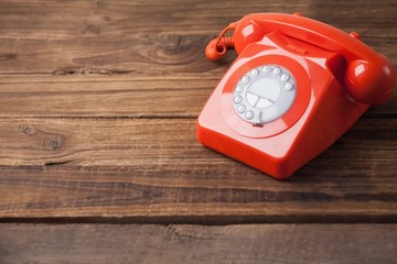 Red telephone on wooden table