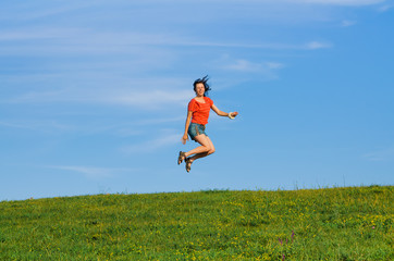 jumping happy emotion woman on grass and sky backgrounds