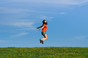 jumping happy emotion woman on grass and sky backgrounds