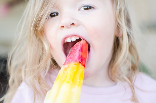 Portrait of a girl eating an ice lolly