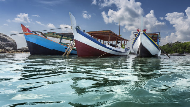Three boats anchored at beach, Belitung Island, Indonesia