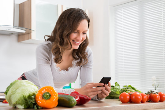 Woman Smiling While Using Mobile Phone