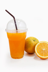 Orange juice in plastic clear cup and orange fruit