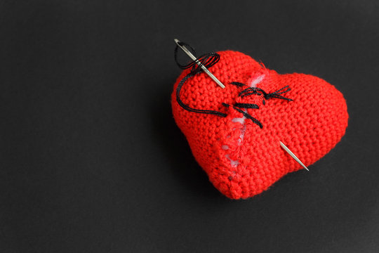 Broken red heart  sewn with thread