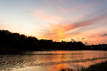 Pink sunset on the river with a view of alley