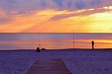 two people fishing by the sea