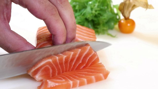 Sushi Chef Slices a Salmon Steak Nigiri Style.
A sushiman slicing a salmon steak with his Japanese knife.
Preparing sushi nigiri fish.
Japanese cuisine recipes.