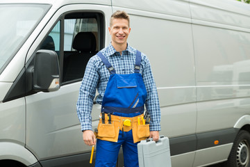 Repairman With Tools And Toolbox In Front Of Van