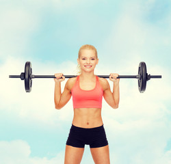 Obraz premium smiling sporty woman exercising with barbell