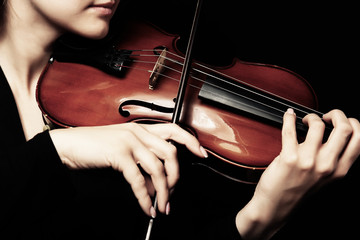 Violinist playing violin on dark background