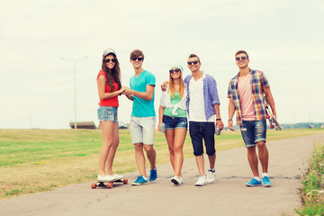 group of smiling teenagers with skateboards