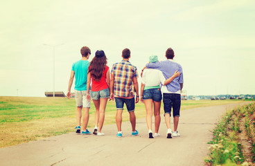 group of teenagers walking outdoors from back
