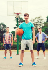Obraz premium group of smiling teenagers playing basketball