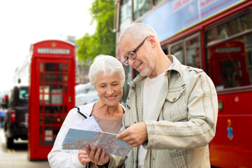 senior couple with map on london in city street