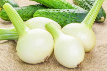 Fresh organic onions with cucumbers on the back