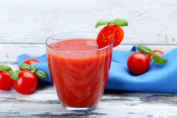 Glass of tomato juice with vegetables on wooden background